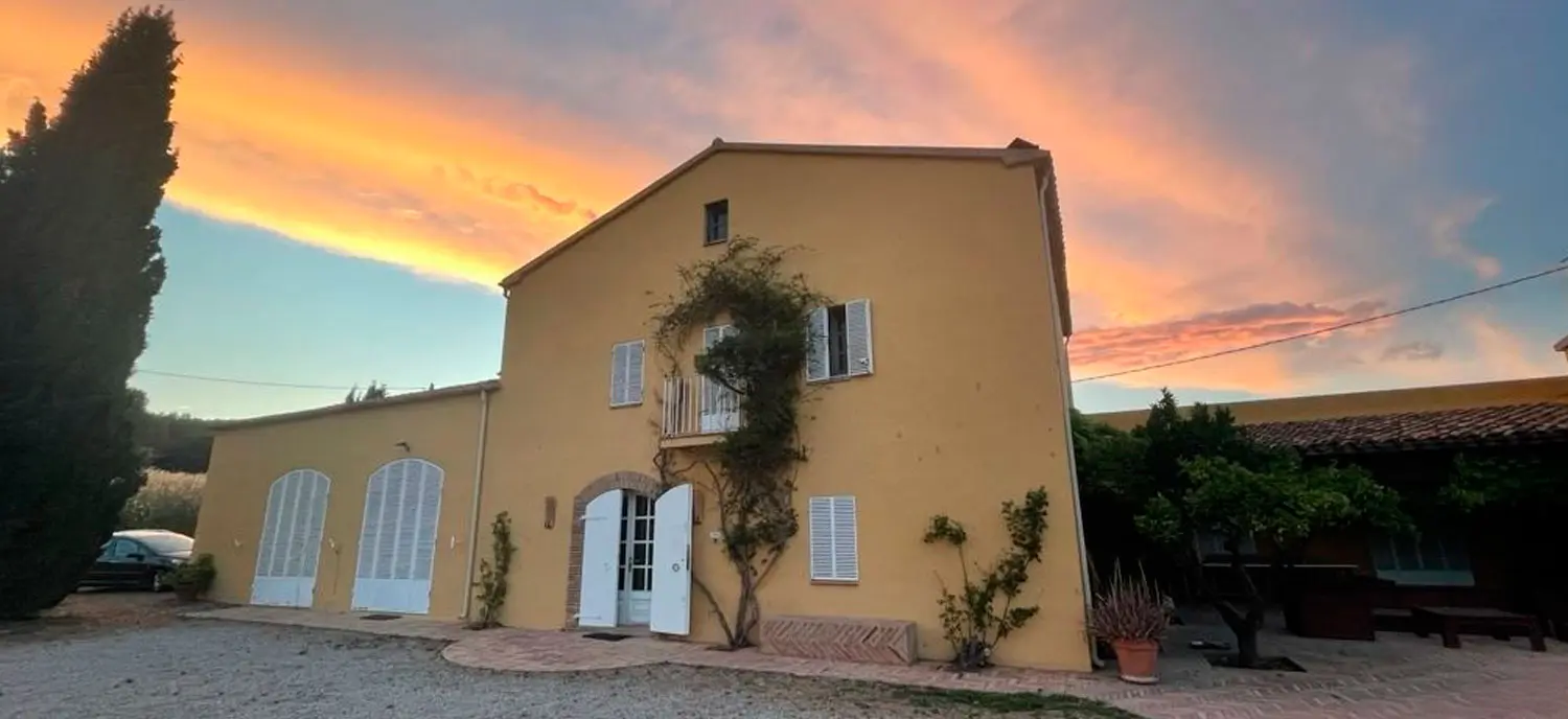 Vista exterior de una casa rural amarilla en el Penedès